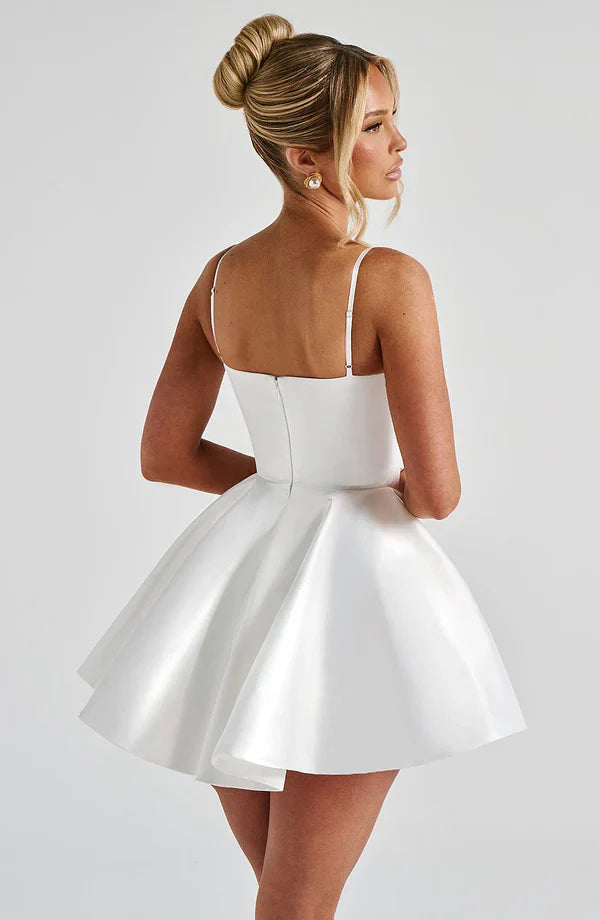 Woman in an ivory Poppy Mini Dress with underwired cups and a voluminous circle skirt, showcasing a timeless style.